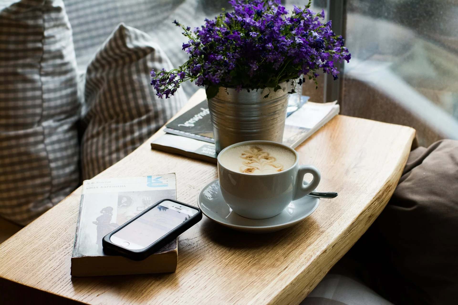 Smartphone posé sur une table basse à côté d’une tasse de café
