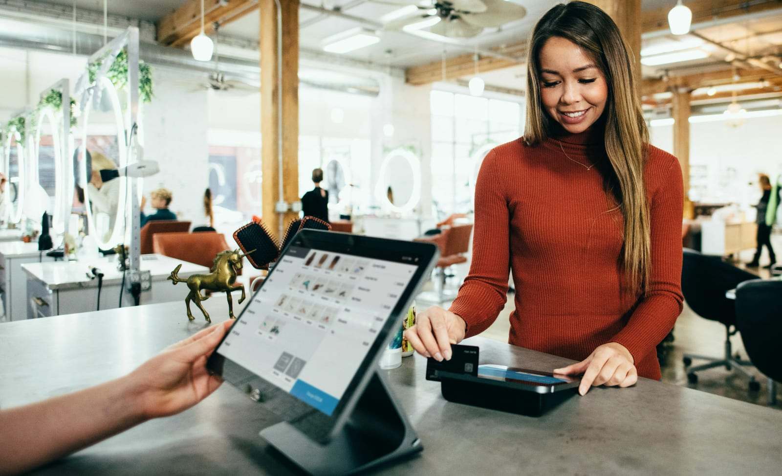Commerçante encaissant un client sur une caisse enregistreuse tactile