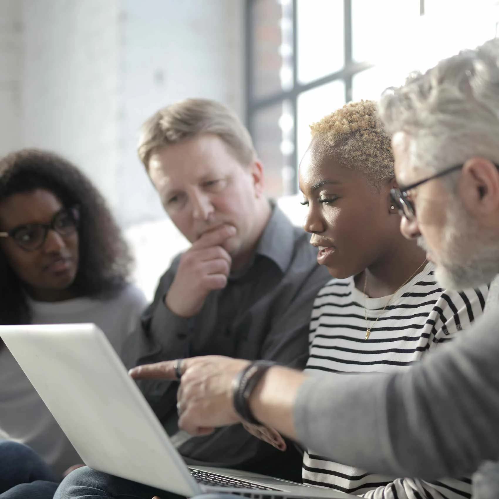 Équipe de consultants échangeant autour d’un ordinateur portable